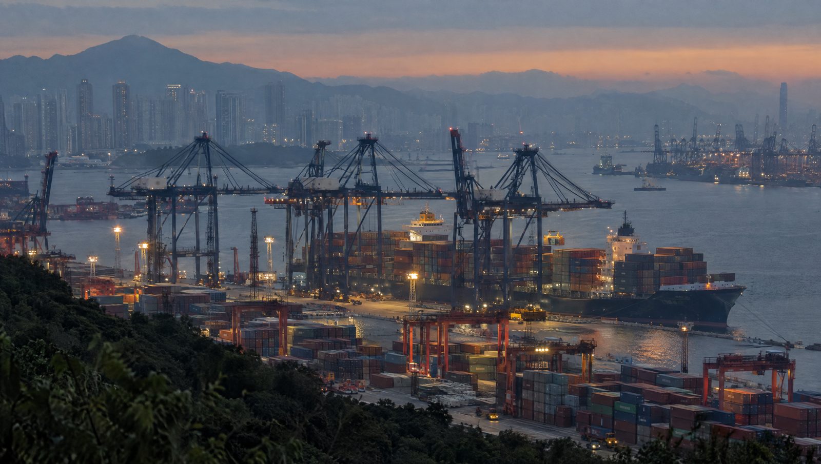 Container cranes and ships at Kwai Tsing Container Terminals at dusk
